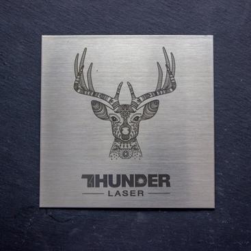 laser engraver product image: a shiny grey metal plate with a deer engraved with the logo Thunder laser canada underneath