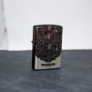 laser engraver product image: a shiny grey metal zippo lighter engraved with a pattern and the logo Thunder laser canada underneath-buy Thunder Laser Canada engraver machines