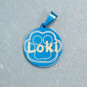 laser engraver product image: a shiny metal blue animal tag engraved with the word "Loki" and a footprint of a cat
