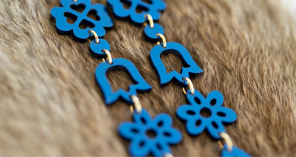 blue laser cut wood earrings. Different types of the outlines of flowers made with a laser cutter strung together in a chain-Thunder-Laser-Canada Made by Indicity.