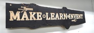 a laser cut sign made with a Thunder Laser. Live edge wood with Make Learn Invent -etched into the wood.
