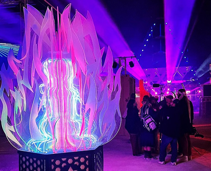 Laser cut light up sculpture depicting flames created with acrylic and led lighting. Photo taken at night at an indoor event. Made on a Thunder Laser laser cutter machine