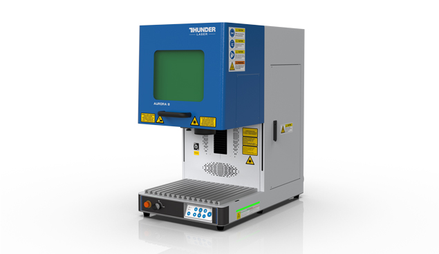 a product shot of the Aurora laser marking machine. It's a small tall machine mostly white with a pull down door that is square and blue with a eye protection window with green glass. The door is up in the photo