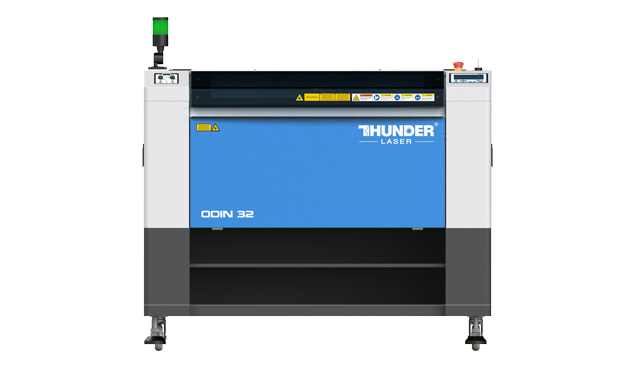 Thunder Laser laser cutter machine . A white machine with a blue metal panel in the frontl Says Odin 32 and Thunder Laser written in white on the panel.