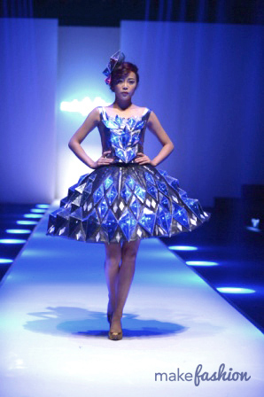 a woman in a light up dress on the runway at a Make Fashion show