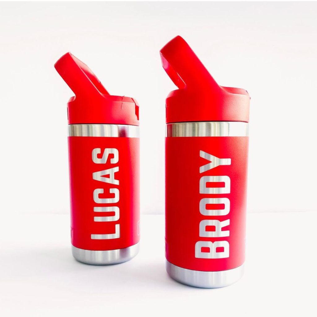 2 laser engraved bright red water bottles matching. One says Lucas and one says Brody in bold large caps font